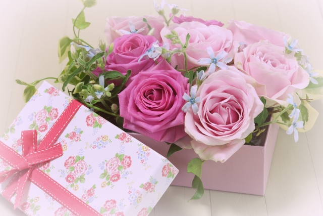濃いピンクや薄いピンクのバラが入ったリボン付きの箱
