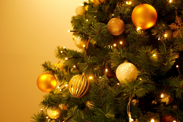 丸い金の飾りがいくつもついたクリスマスツリーの写真