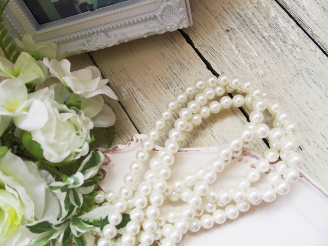 白い花と真珠のネックレスが写っている写真