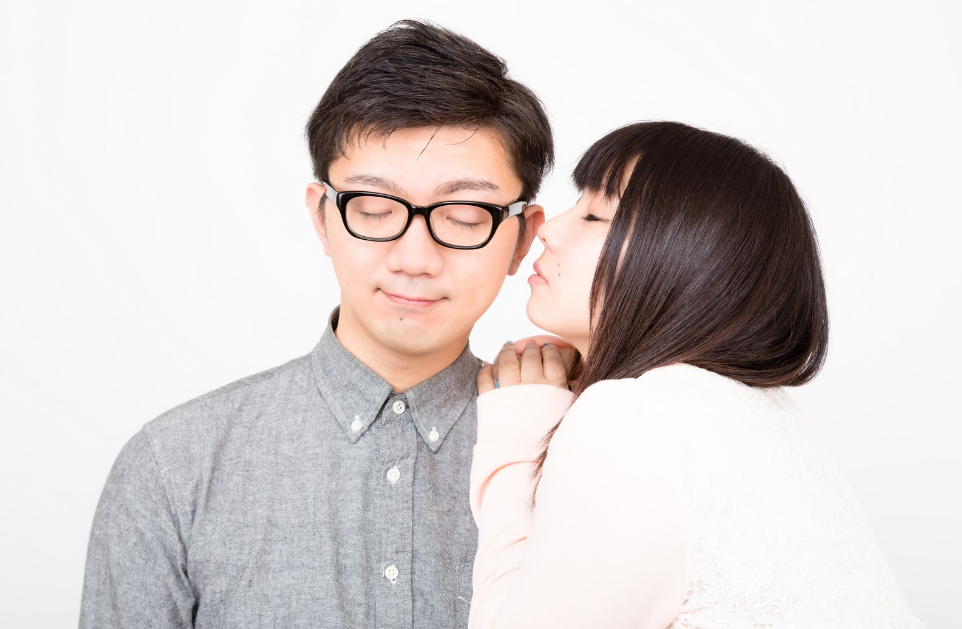 ほっぺたにキスをしようとする彼女と穏やかな表情の彼氏